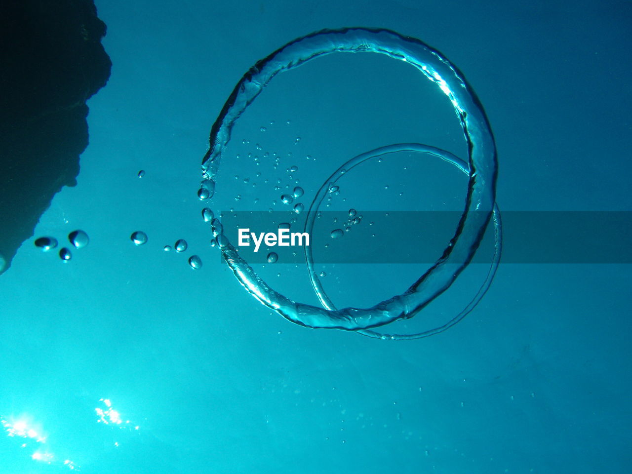 Low angle view of bubble ring in sea against sky