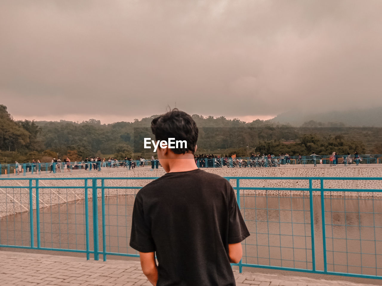 Rear view of man standing on mountain against sky