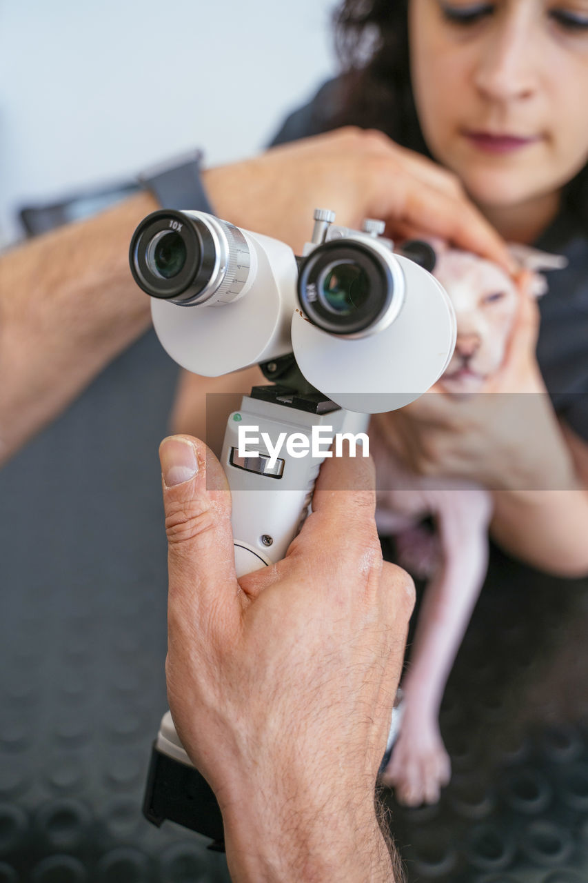 MIDSECTION OF COUPLE HOLDING CAMERA