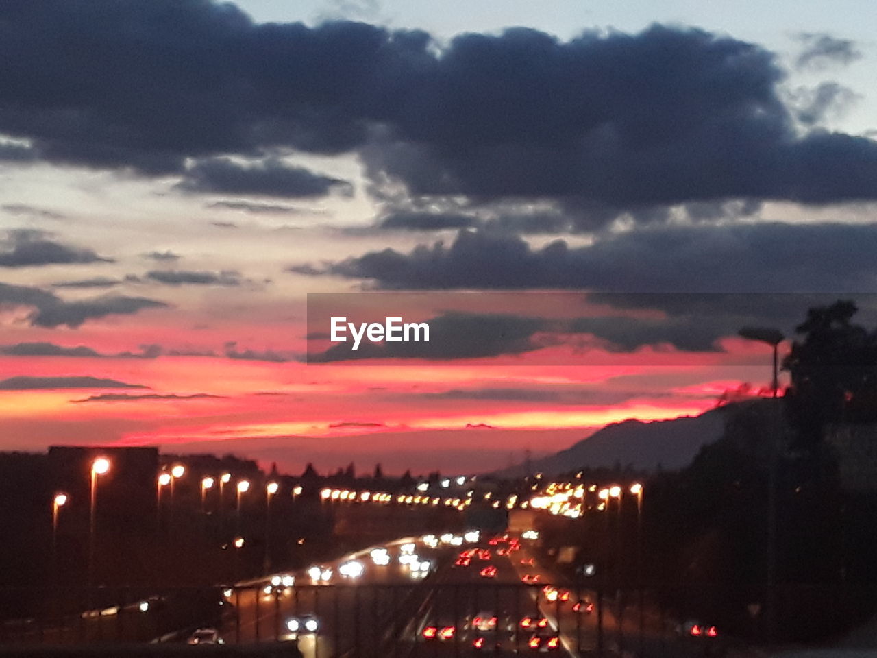 ILLUMINATED CITYSCAPE AGAINST SKY AT SUNSET