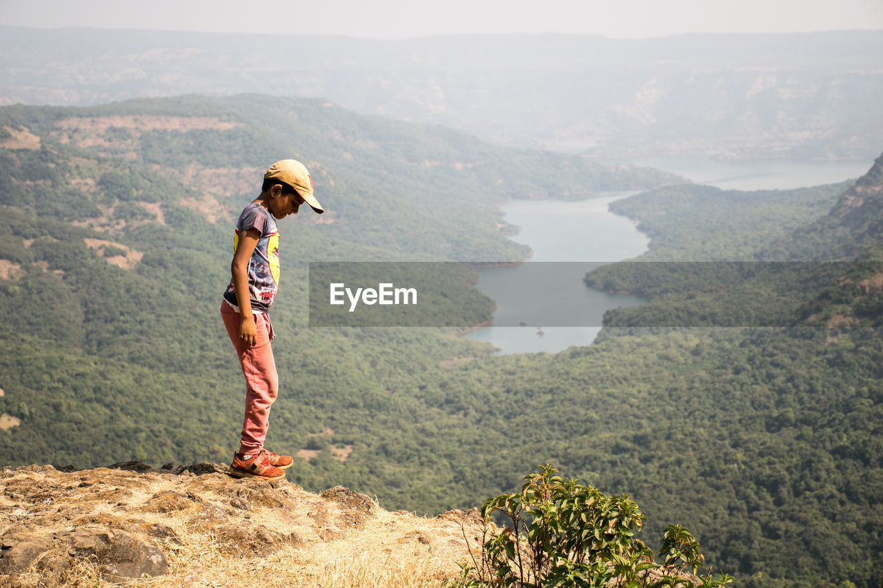 Side view of boy standing on mountain