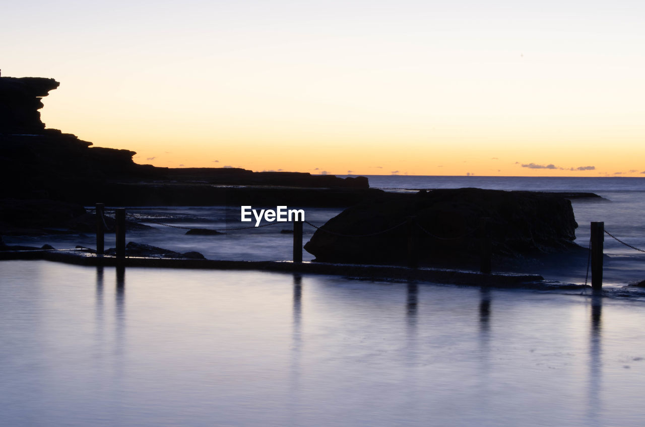 Scenic view of sea against clear sky during sunset