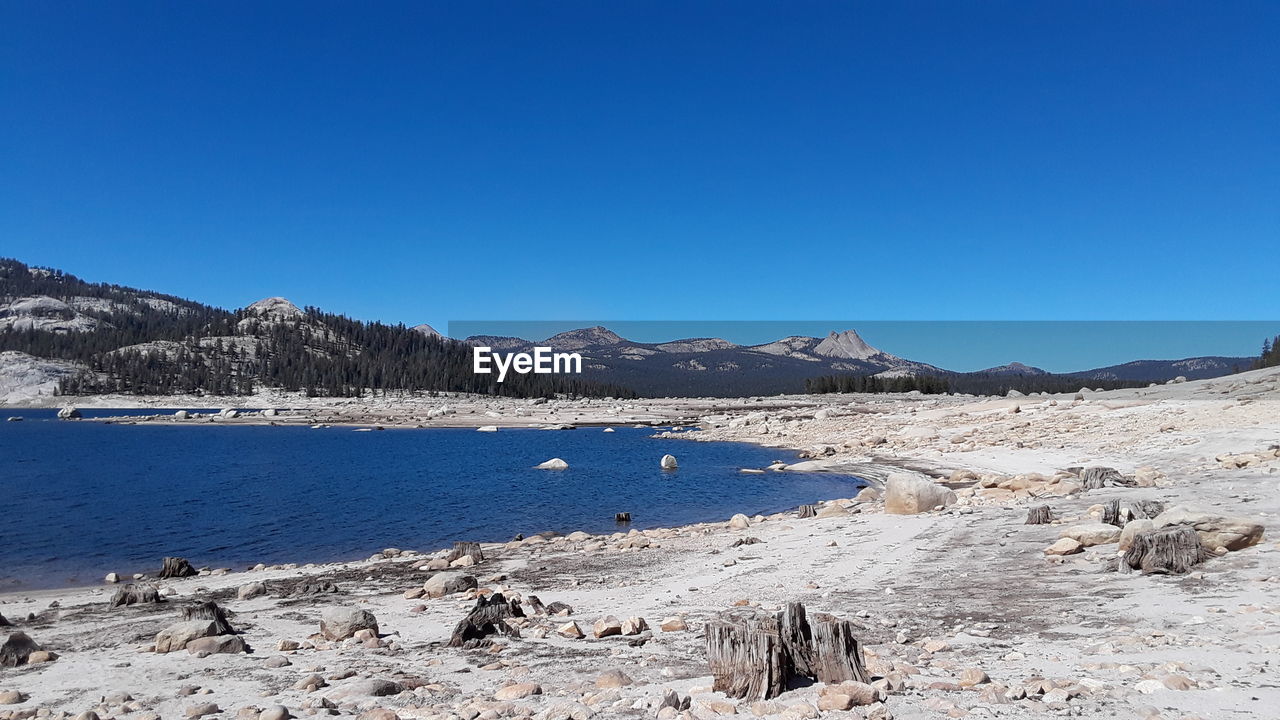 SCENIC VIEW OF SEA AND MOUNTAINS AGAINST BLUE SKY