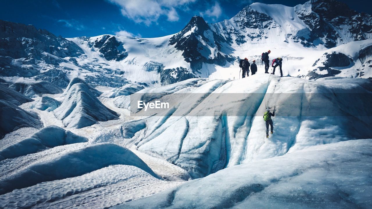 SNOW COVERED MOUNTAINS AGAINST SKY