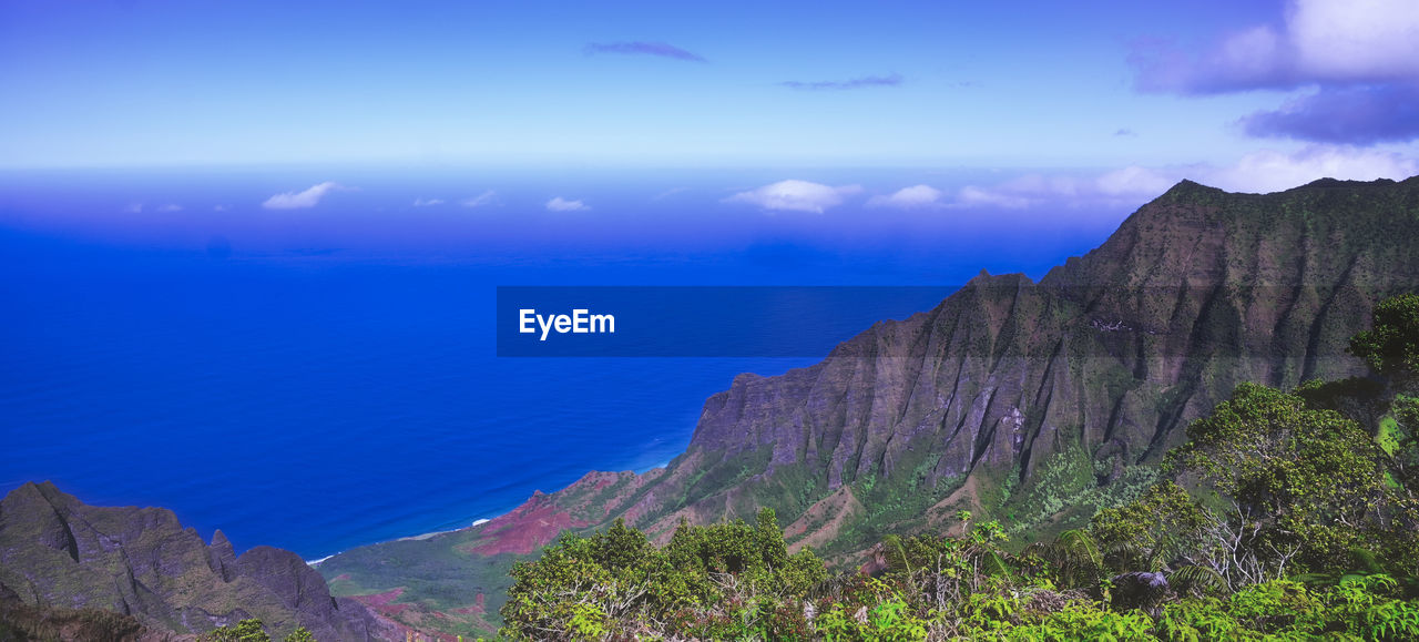 SCENIC VIEW OF SEA BY MOUNTAINS AGAINST SKY