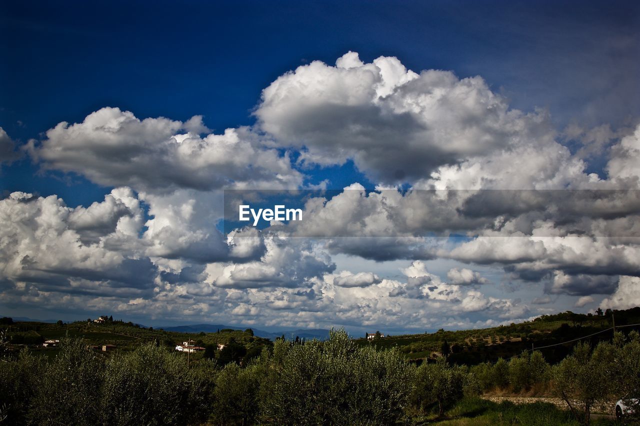 Scenic view of green landscape against cloudy sky