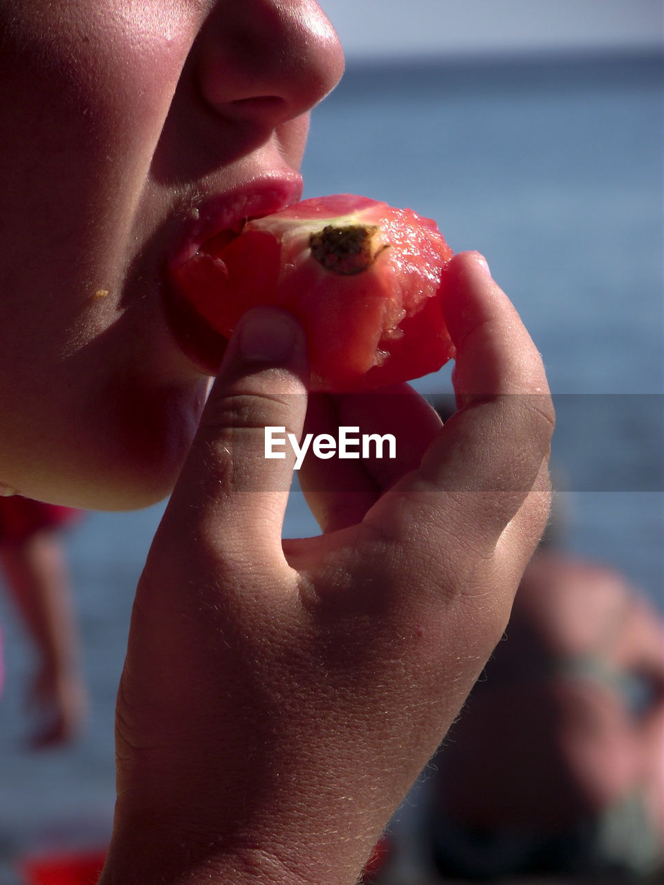 Close-up of girl hand eating tomato