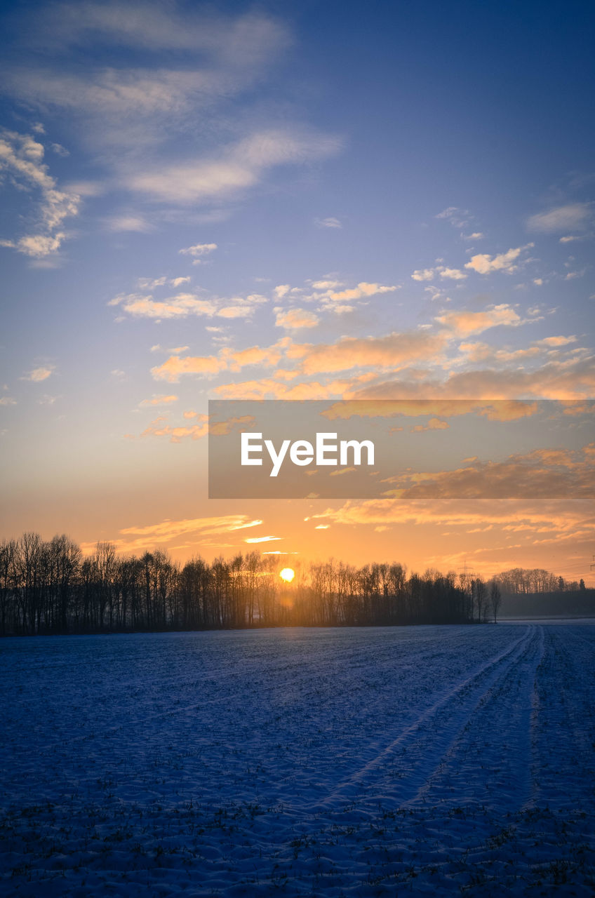 Snow covered landscape at sunset