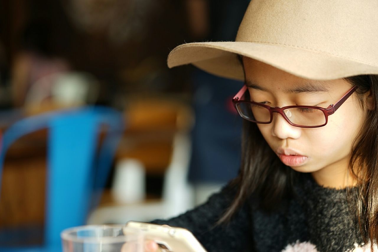 Girl using mobile phone in restaurant