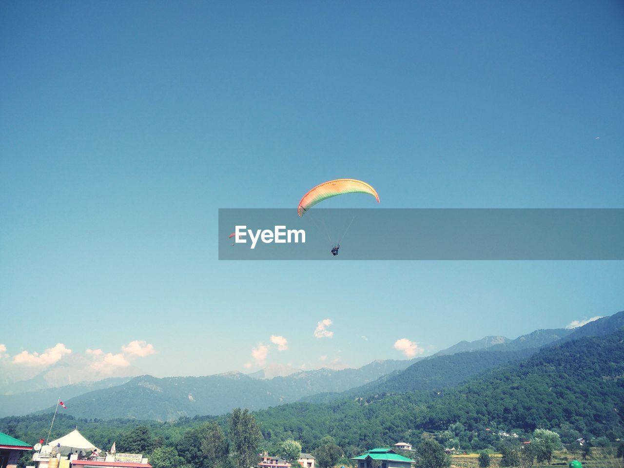 People paragliding over mountain against sky
