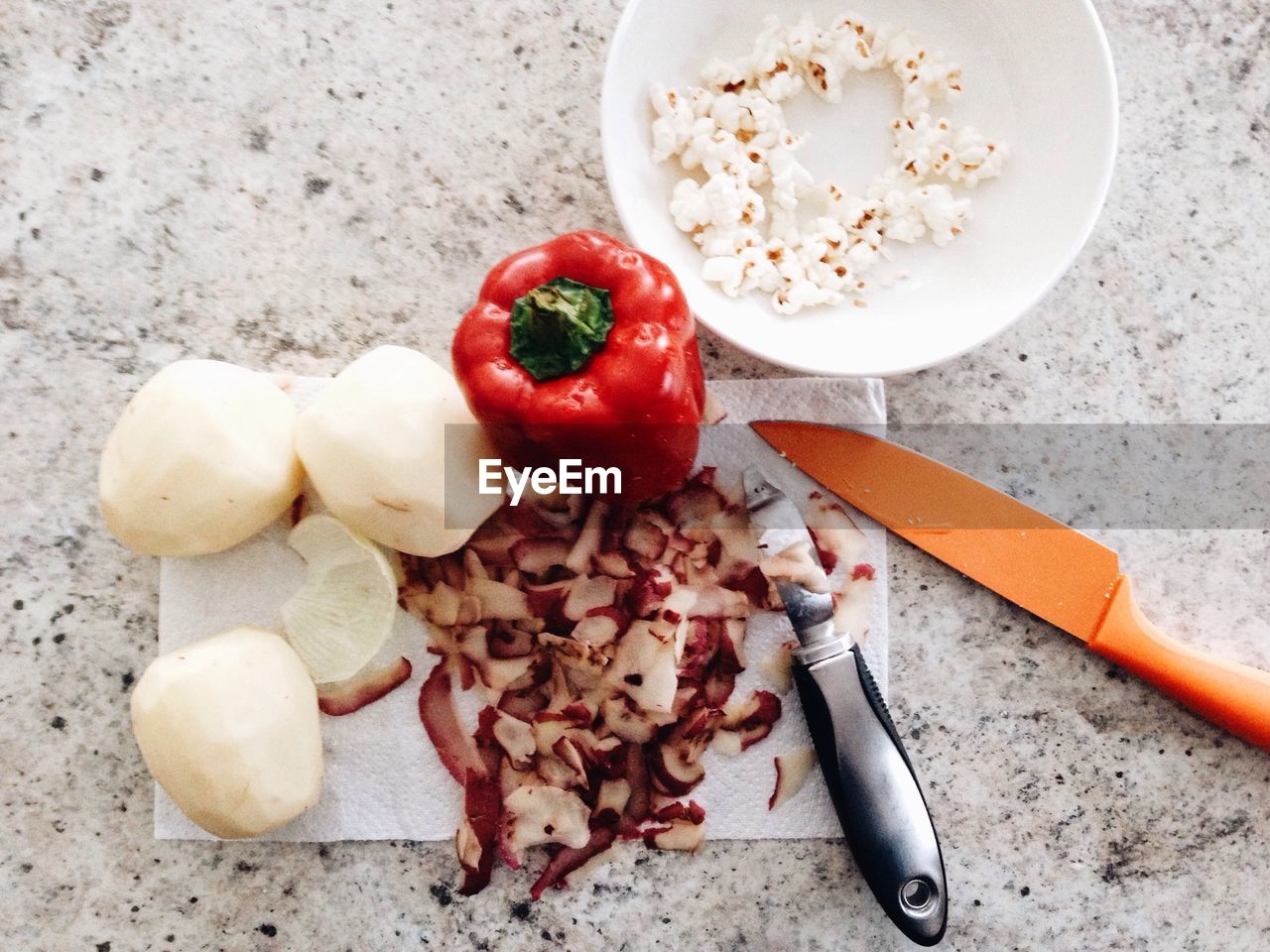 High angle view of vegetables with knives by popcorns on floor