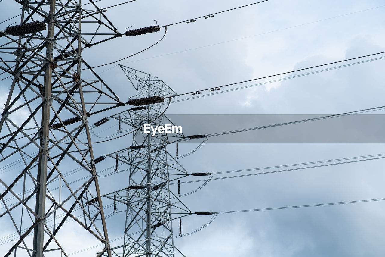 DIRECTLY BELOW SHOT OF ELECTRICITY PYLON AGAINST SKY