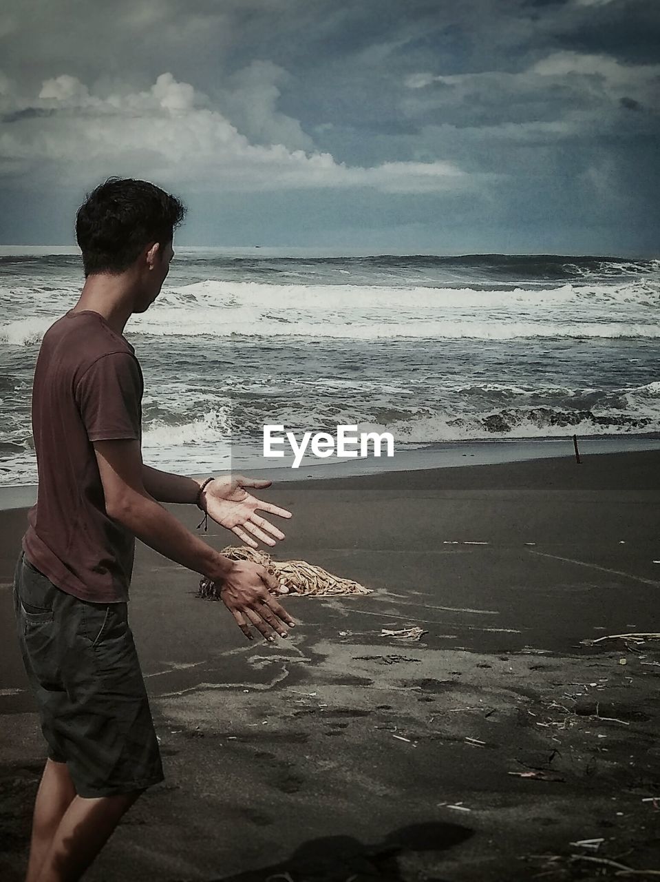 FULL LENGTH OF MAN SPLASHING WATER AT BEACH