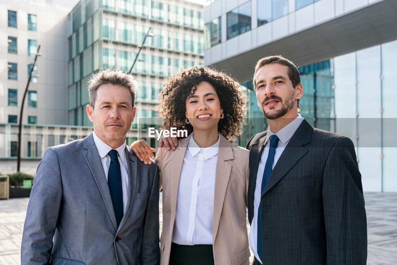 portrait of smiling businesswoman standing against building