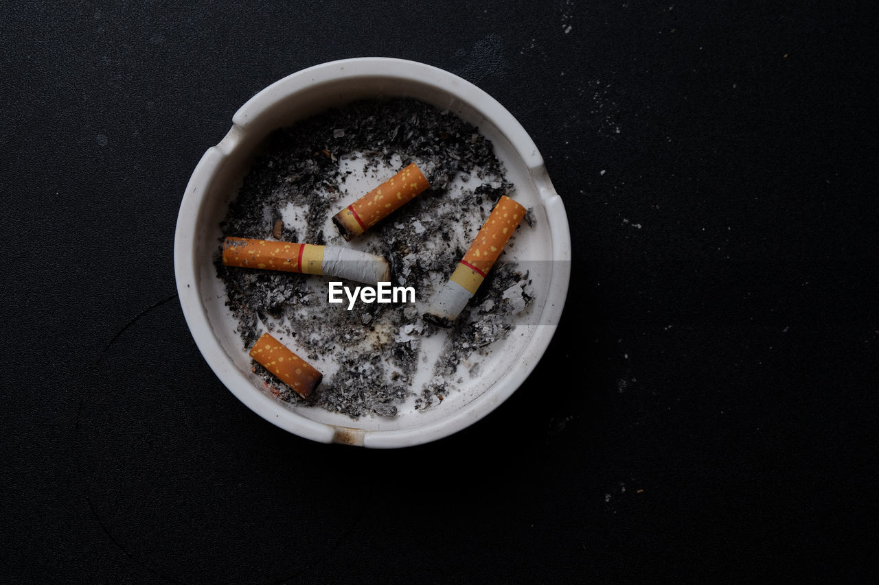 High angle view of cigarettes in ashtray on table