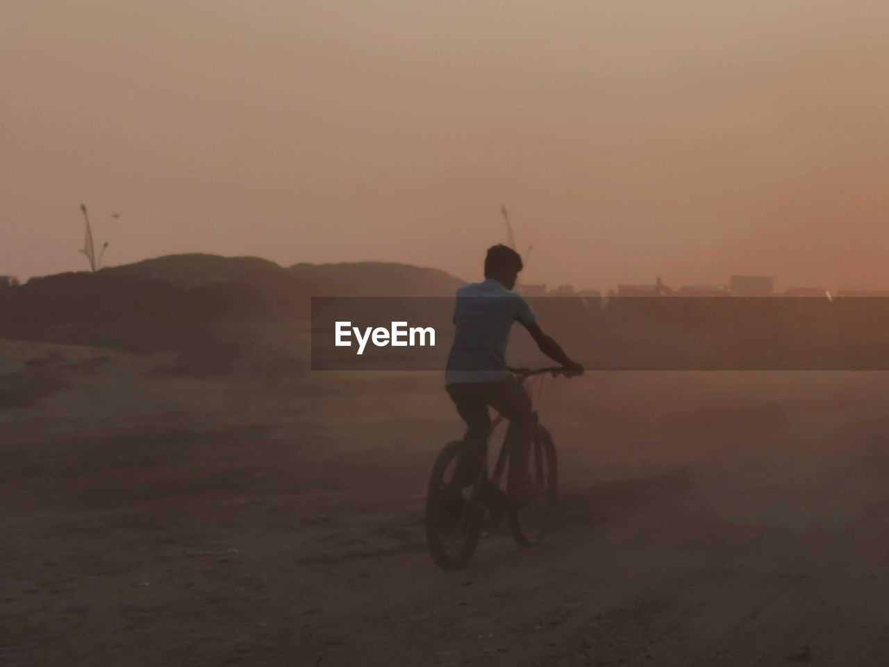 one person, sky, transportation, sunset, fog, nature, riding, natural environment, full length, leisure activity, bicycle, lifestyles, activity, vehicle, land, men, landscape, desert, environment, mode of transportation, sports, adult, cycling, motion, travel, silhouette, scenics - nature, sand, beauty in nature, dusk, copy space, outdoors, land vehicle, helmet, on the move, rear view, mountain, tranquility, exercising, adventure, headwear, motorcycle, non-urban scene