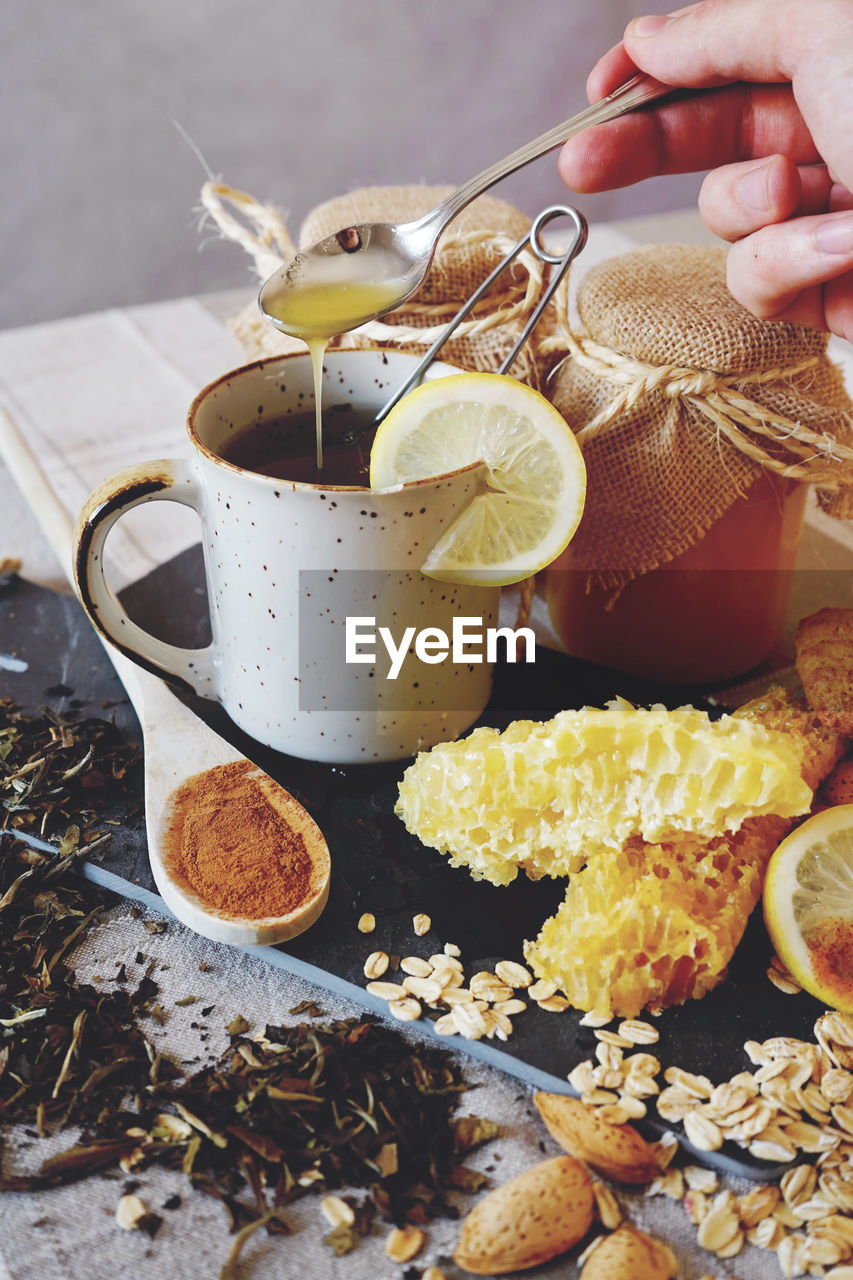 Cropped hand pouring juice in tea