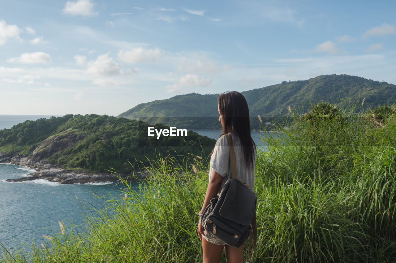 Woman standing on mountain against sky