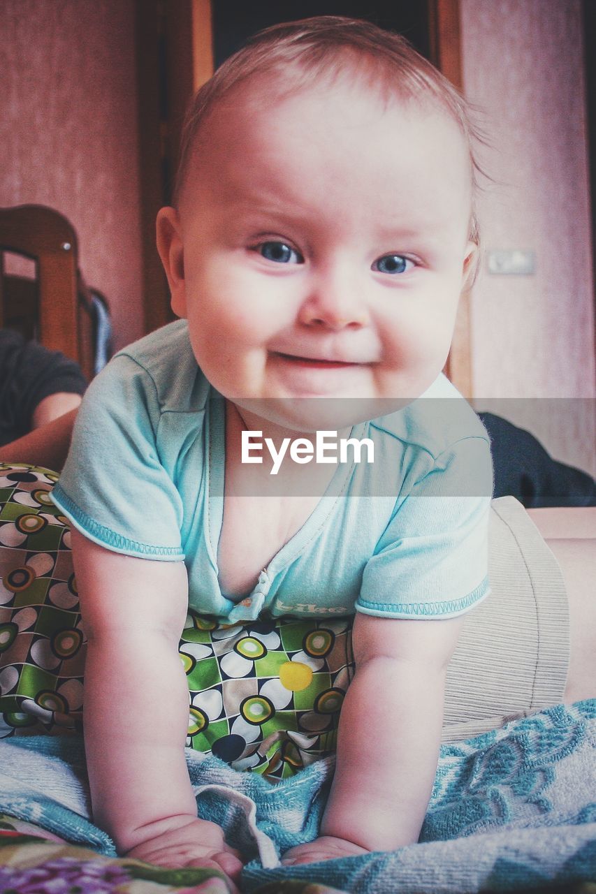 PORTRAIT OF BABY GIRL SITTING AT HOME