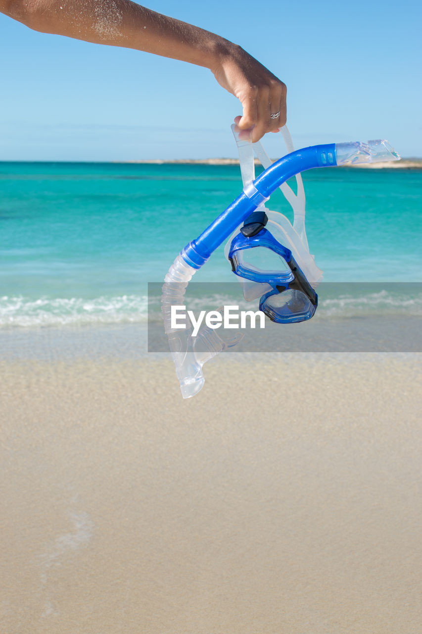 Cropped image of hand holding swimming goggles