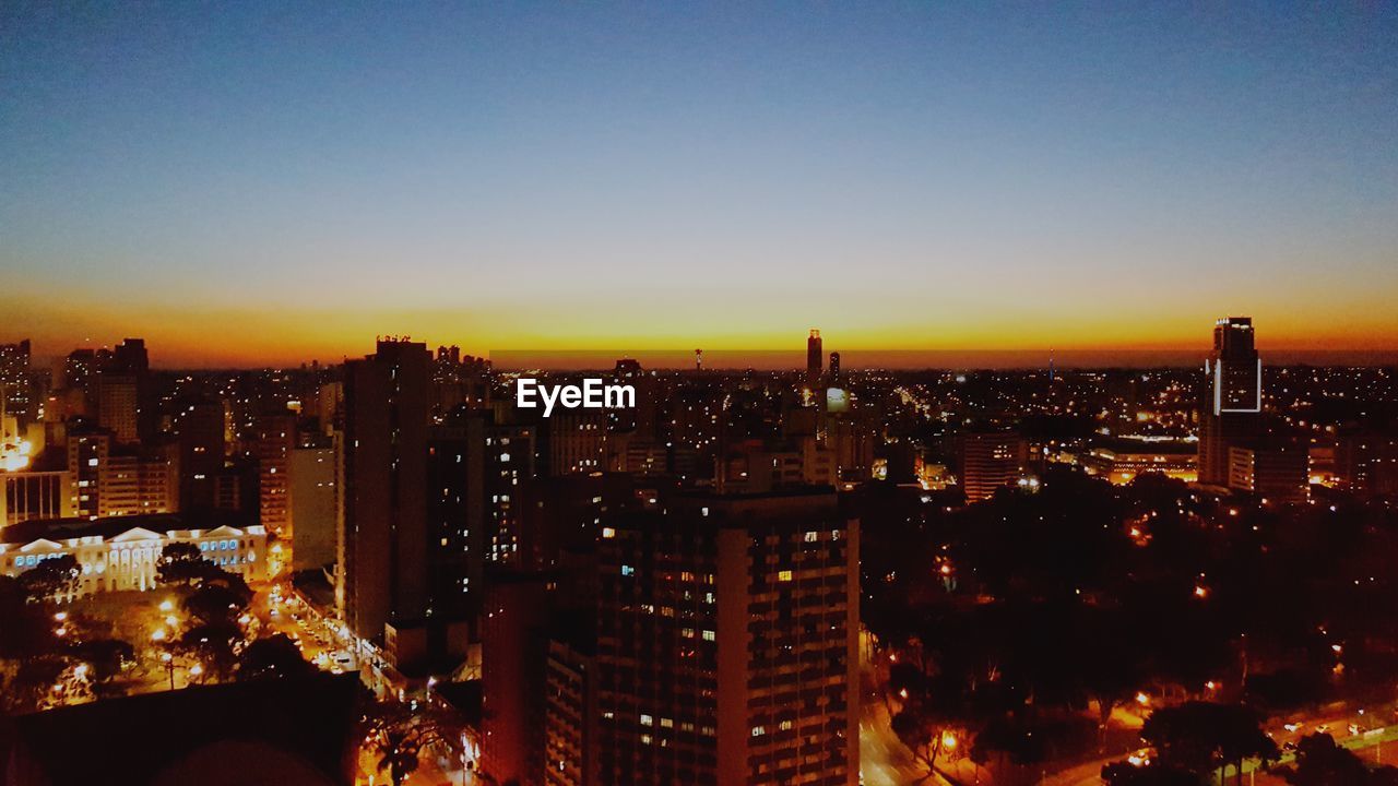 Illuminated cityscape against sky at night