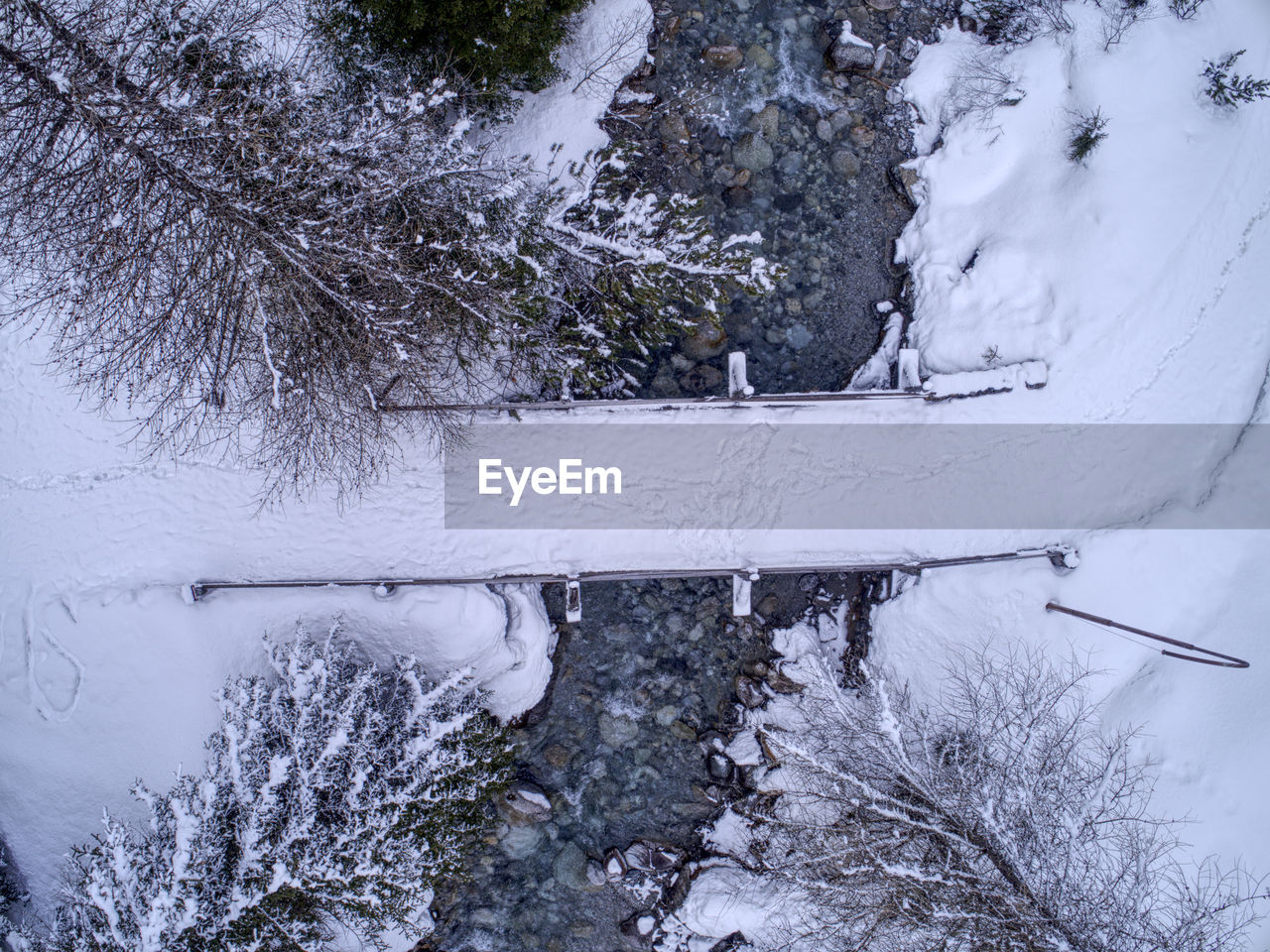 Directly above shot of snow covered bridge over river during winter