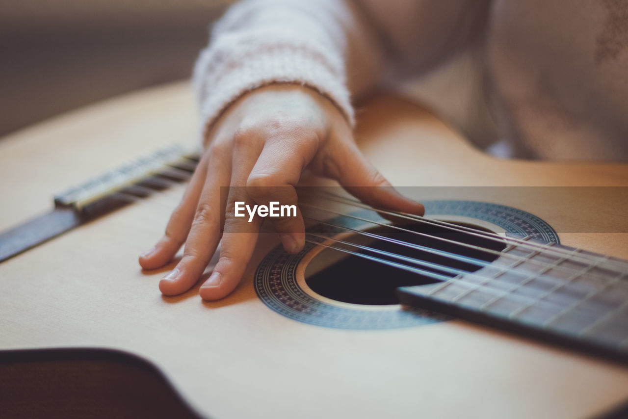 Little girl plays the guitar.