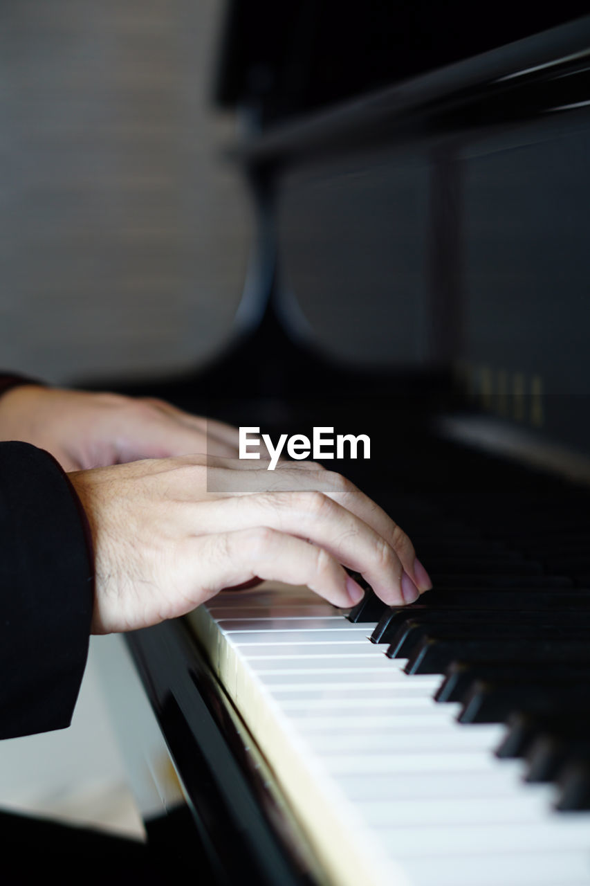 Cropped hands playing piano