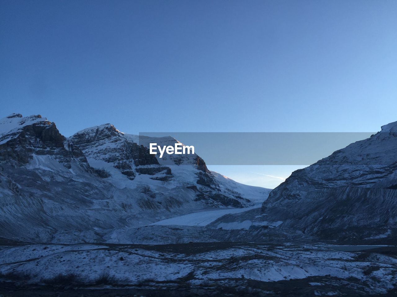 Scenic view of snowcapped mountains against clear blue sky