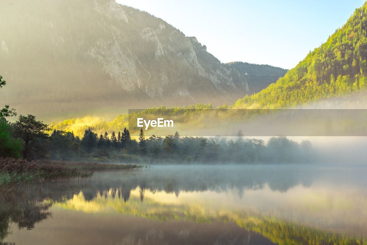 Scenic view of lake by mountains against sky