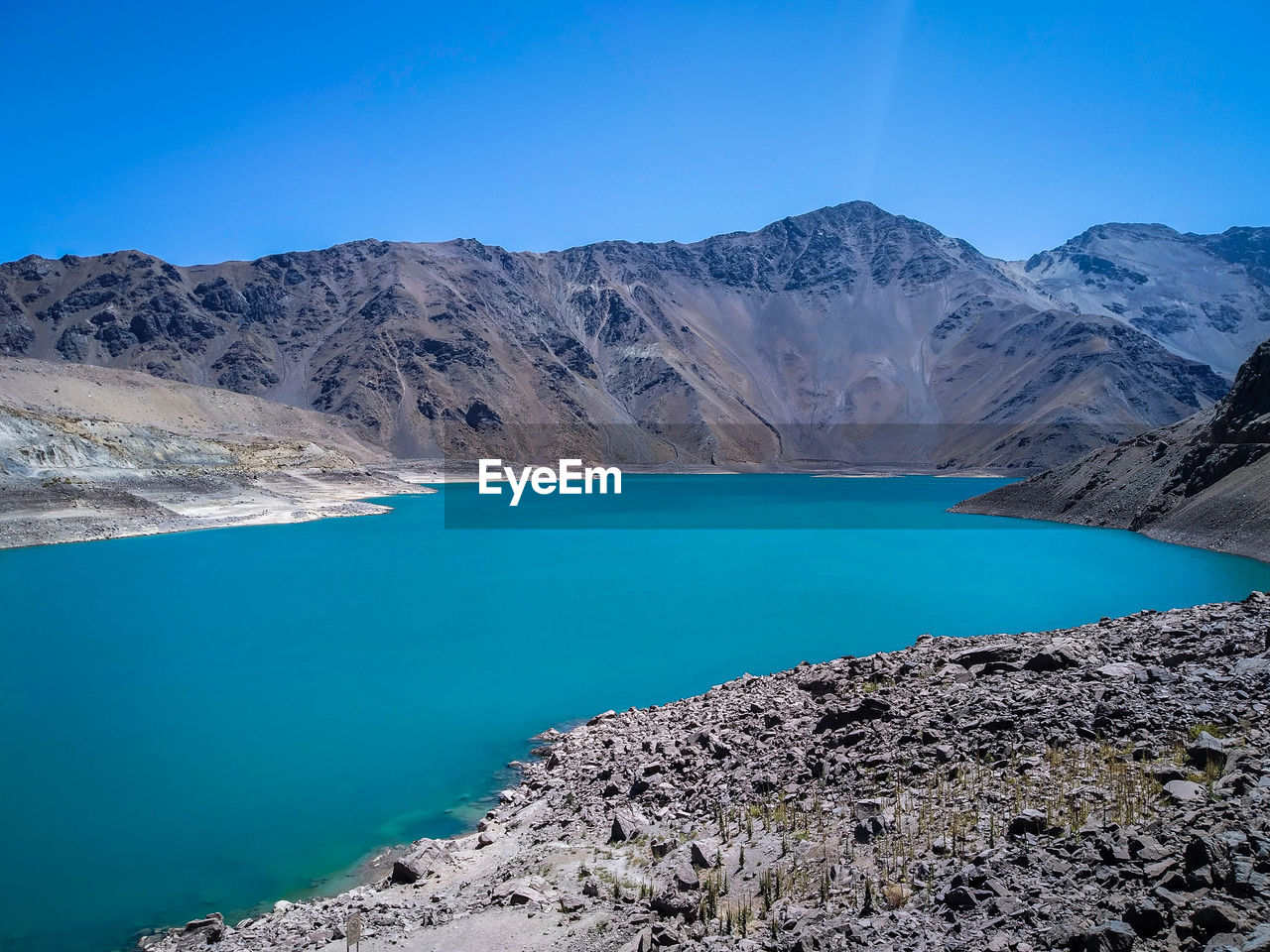 Scenic view of lake and mountains against blue sky