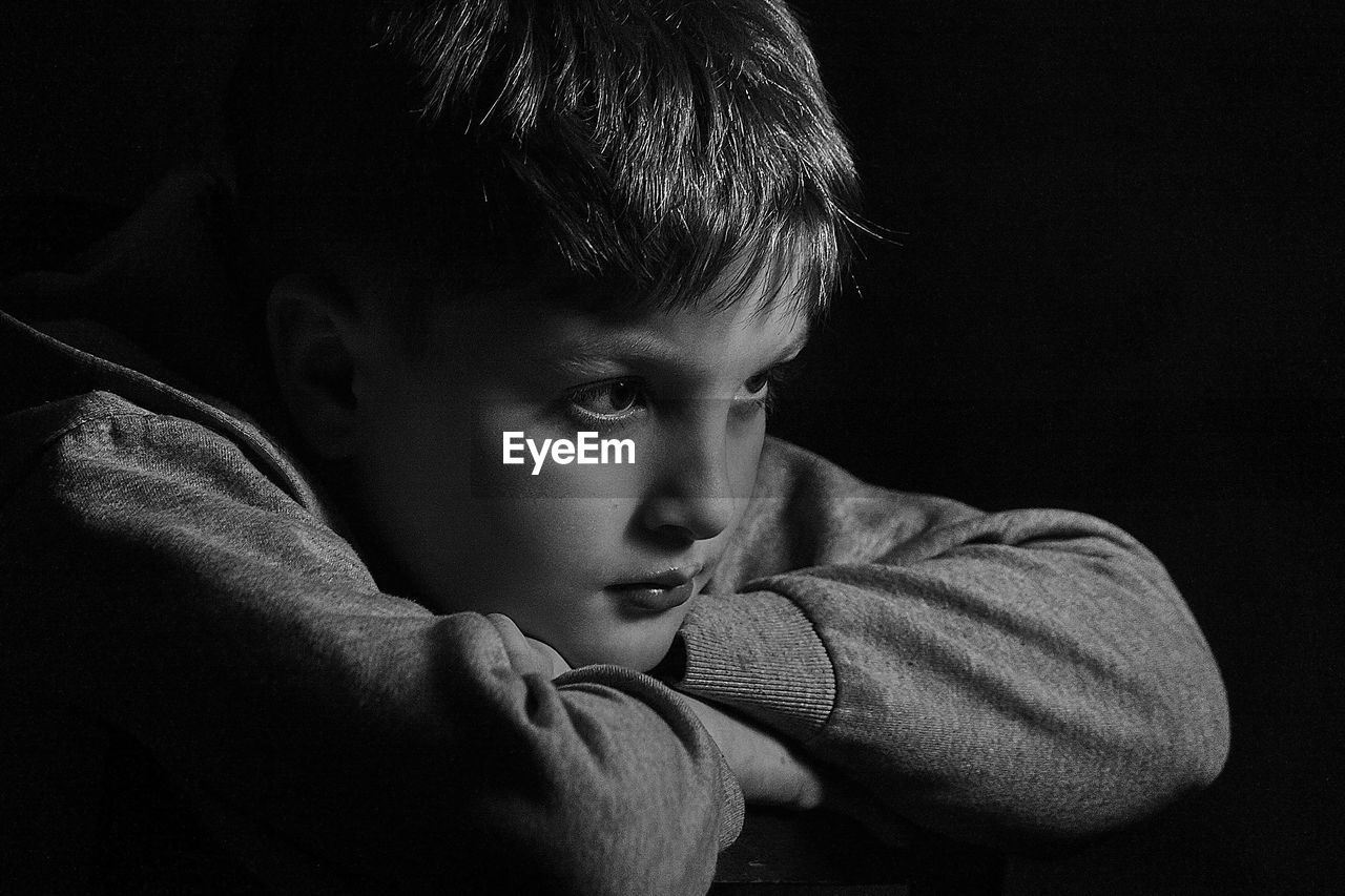 Close-up of thoughtful boy in darkroom