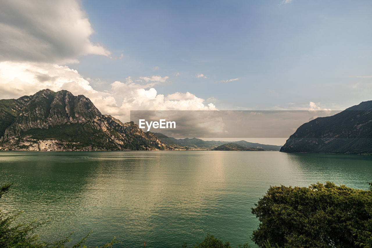 Scenic view of sea and mountains against sky