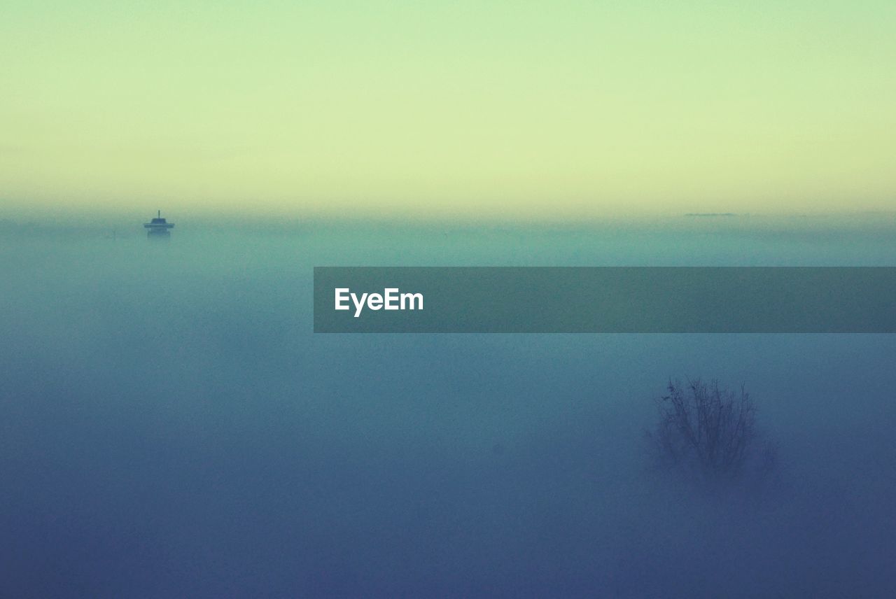 Scenic view of landscape against sky during foggy weather