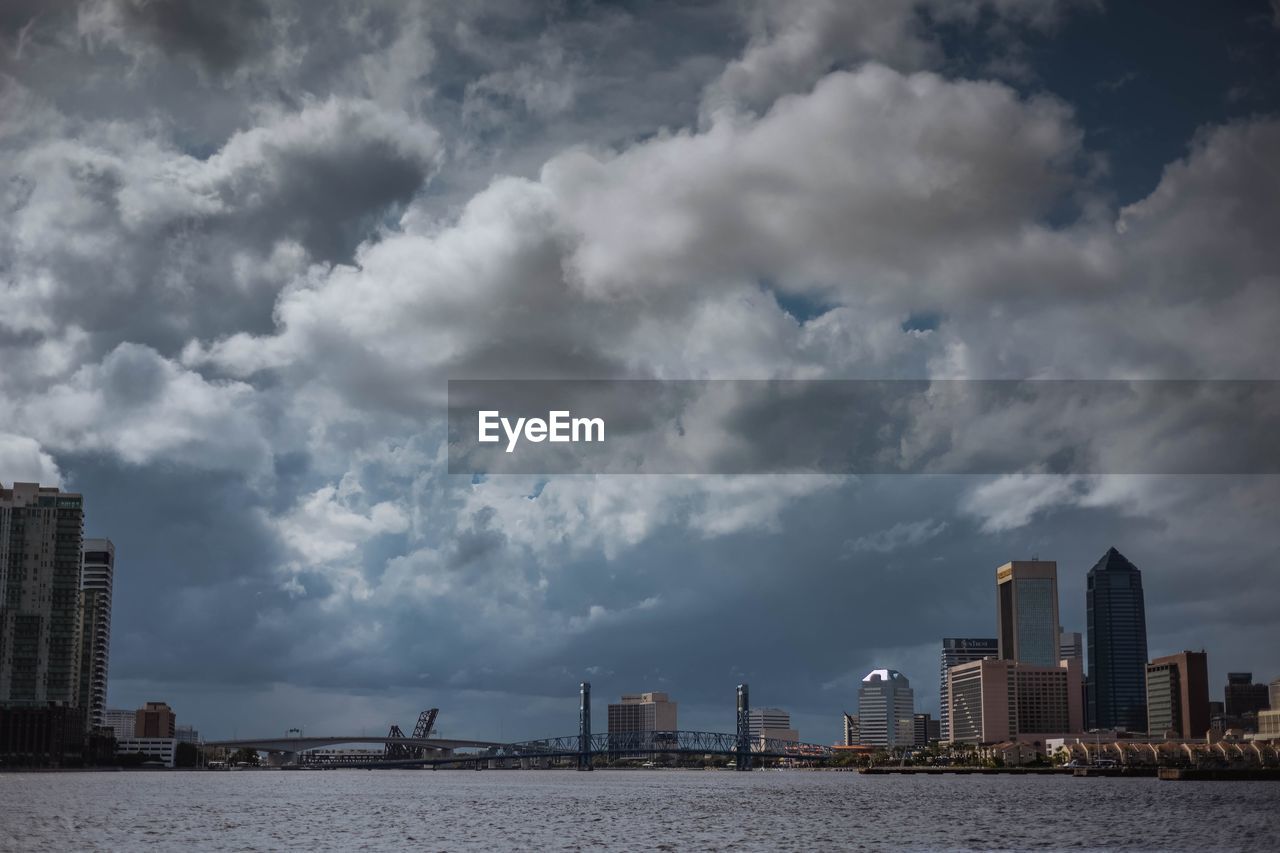 Modern buildings by sea against sky in city