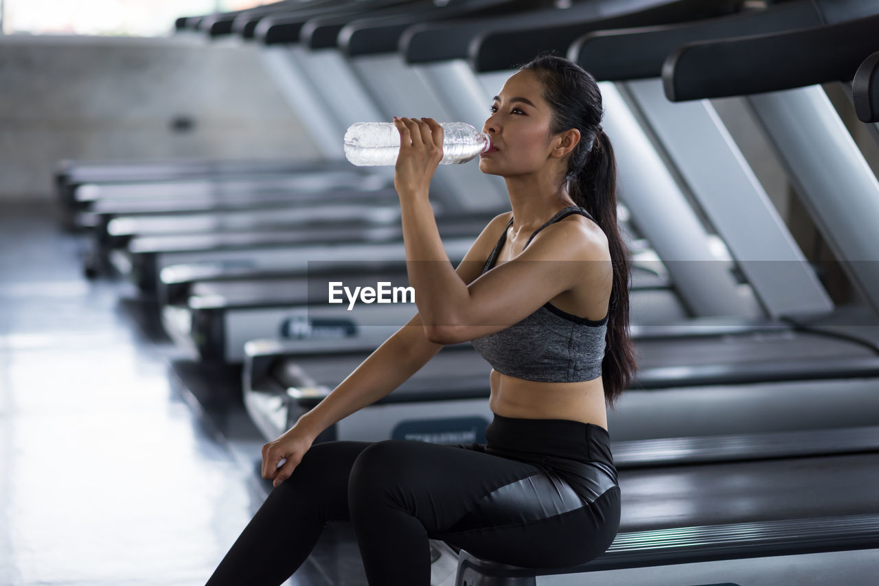 side view of young woman exercising in gym