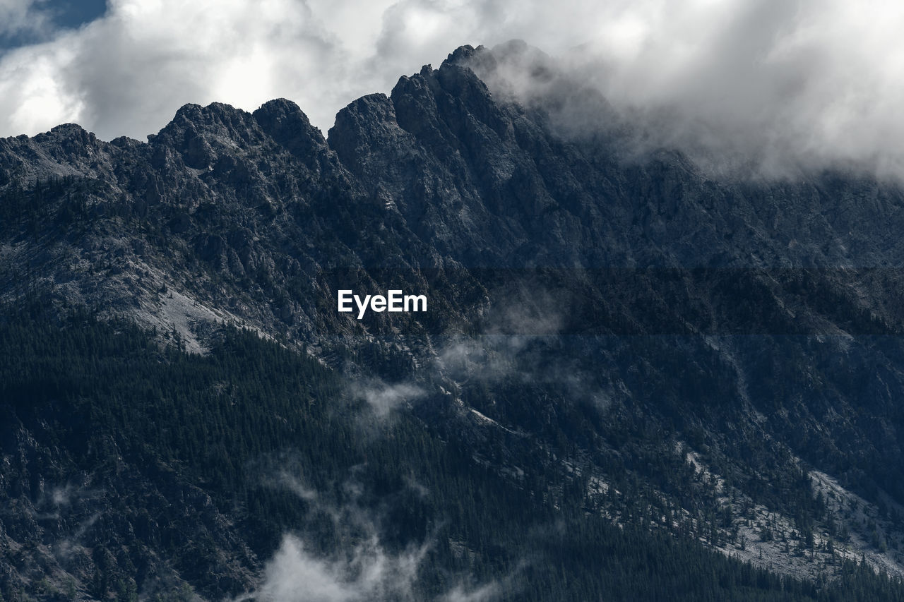 Low angle view of snowcapped mountains against sky