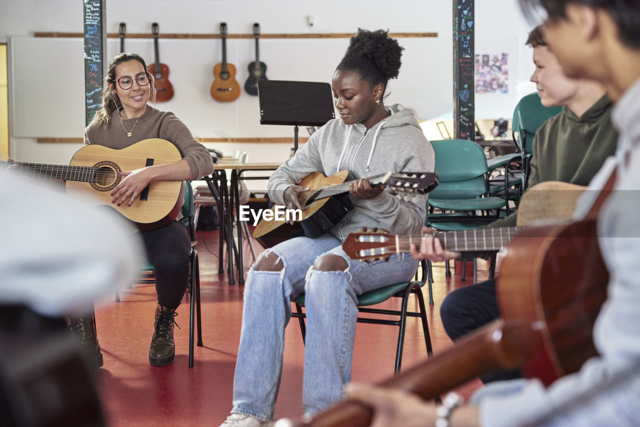 Teenagers attending guitar lesson