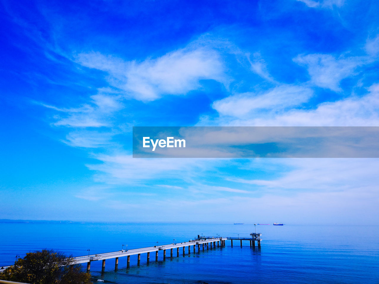 Pier over sea against blue sky