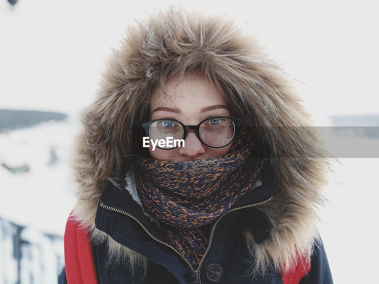 Portrait of young woman in warm clothing standing outdoors