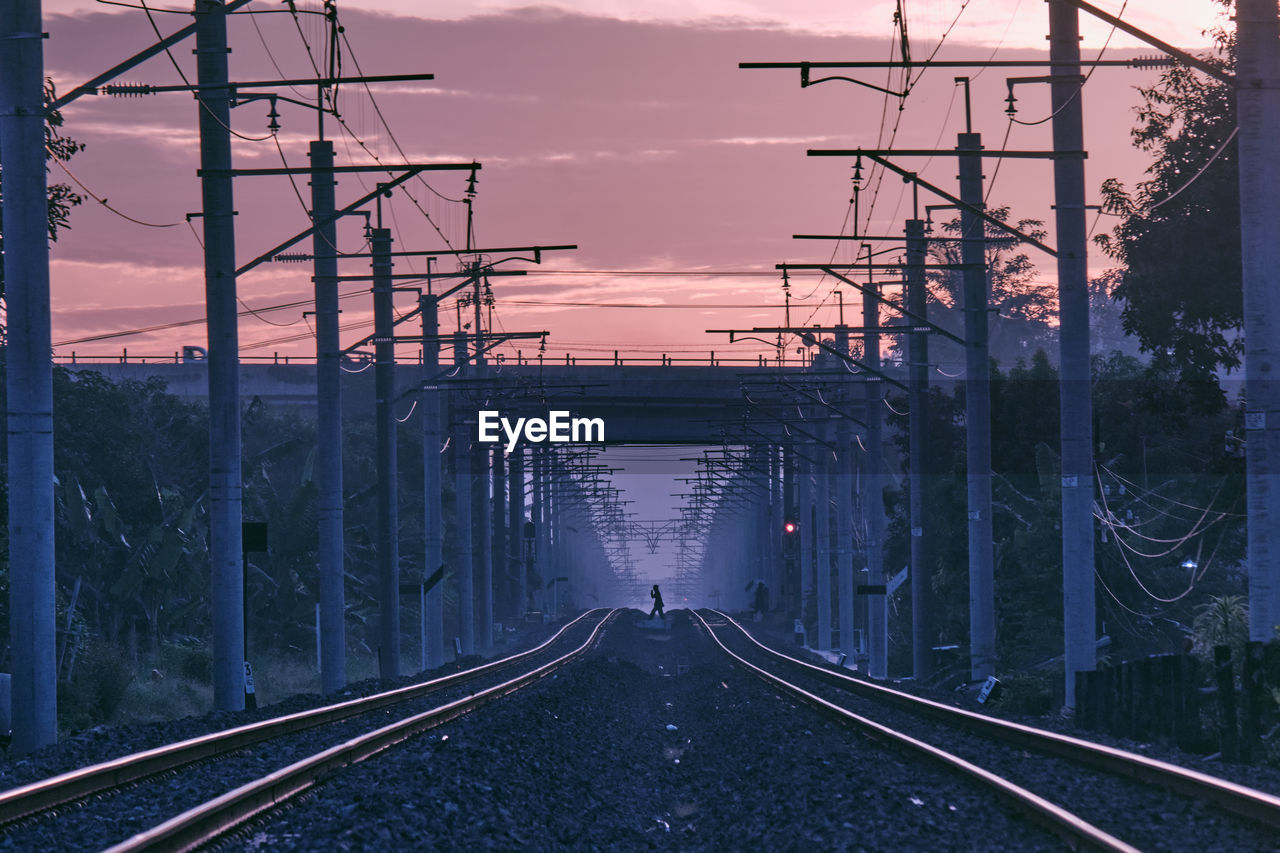 Railroad tracks against sky during sunrise