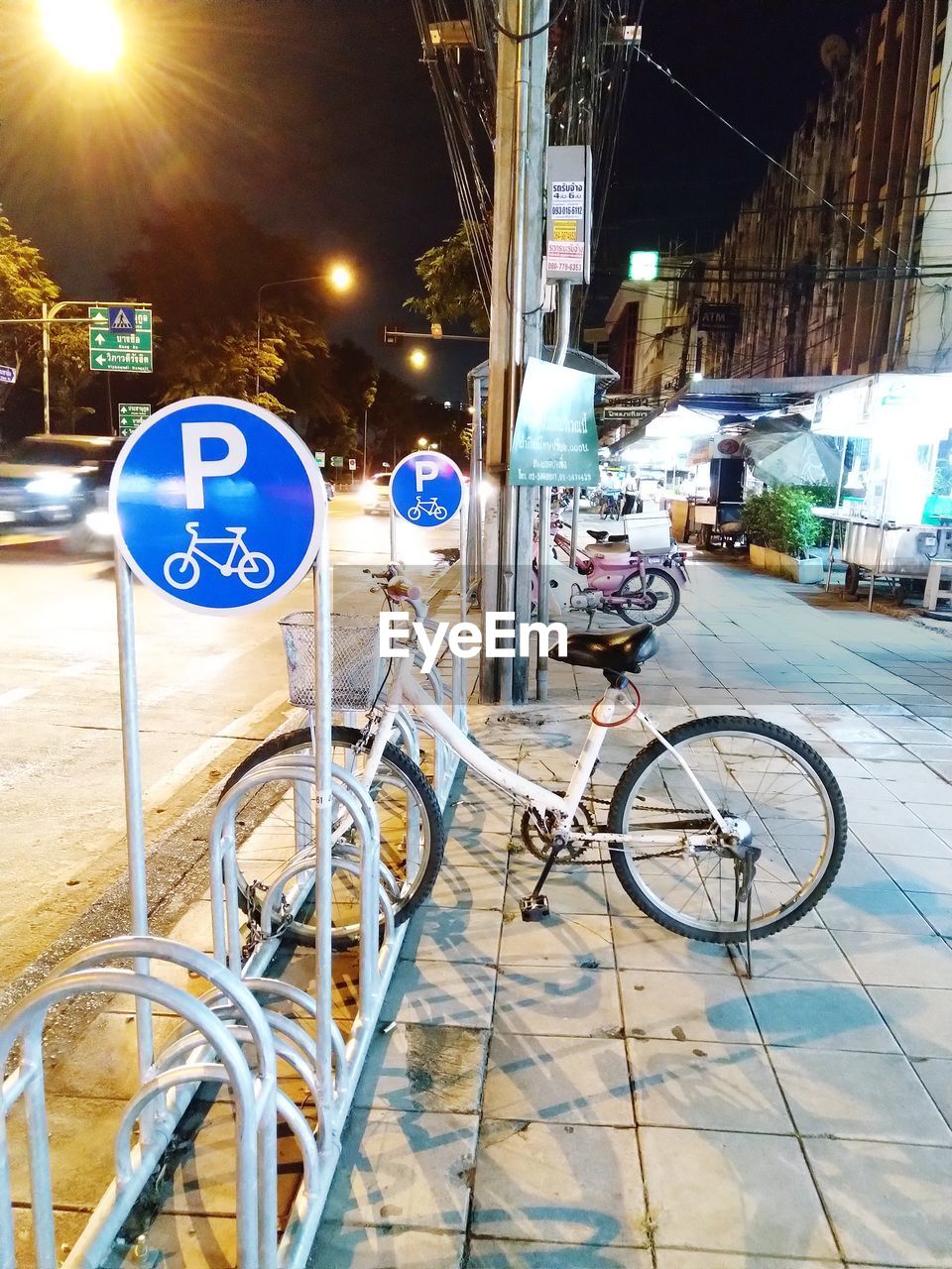 Bicycle parked on street in city at night