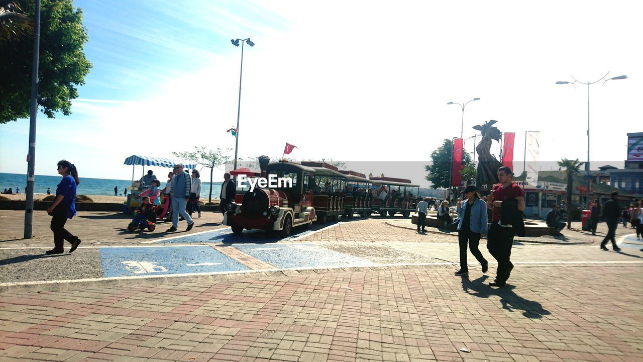 PEOPLE ON STREET AGAINST SKY