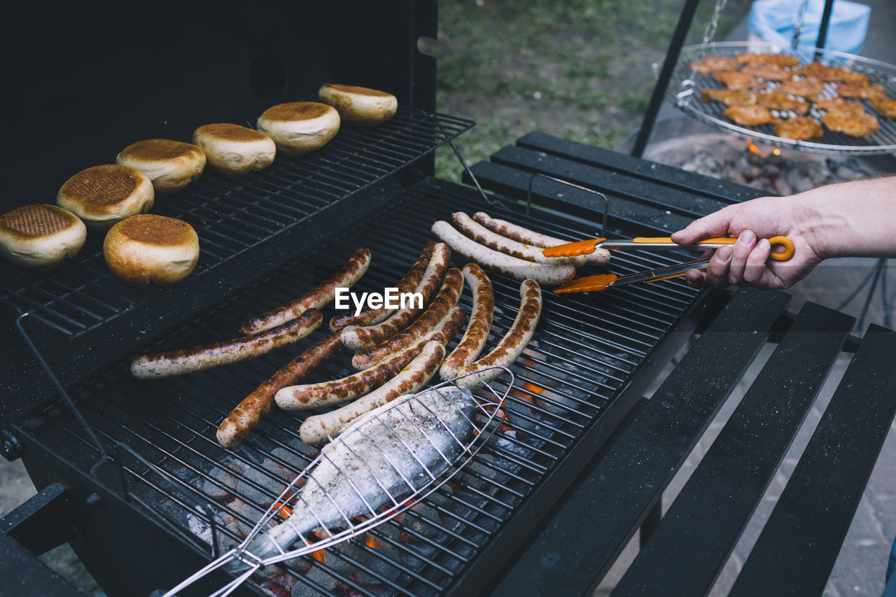 Close-up of fish and sausages on barbecue grill