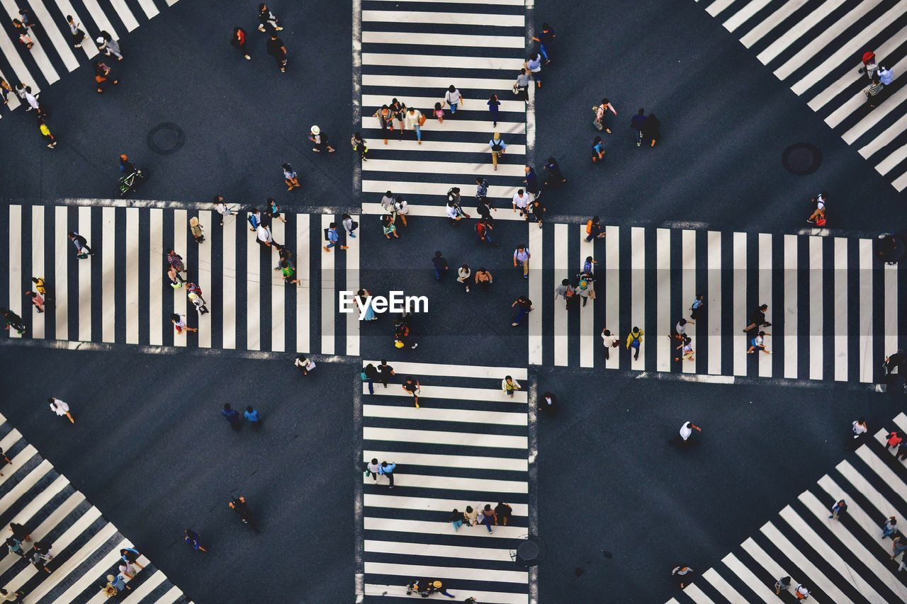 Aerial view of people walking on road intersection in city
