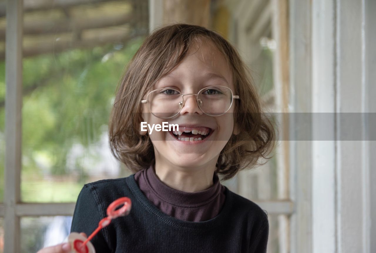 Portrait of cheerful boy wearing eyeglasses at home