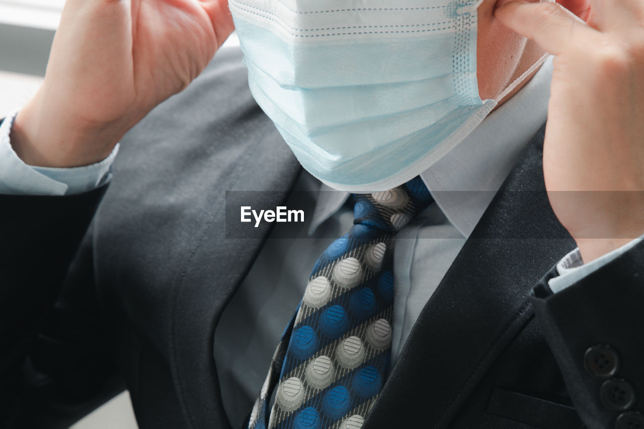 Midsection of businessman wearing mask