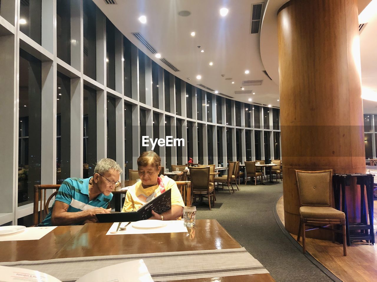 Old couple looking at the menu while sitting in a restaurant 