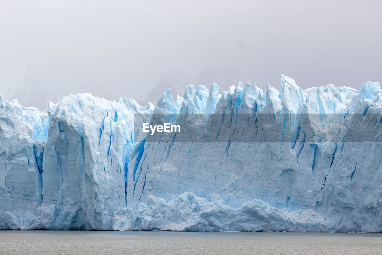 SCENIC VIEW OF SEA AGAINST MOUNTAIN