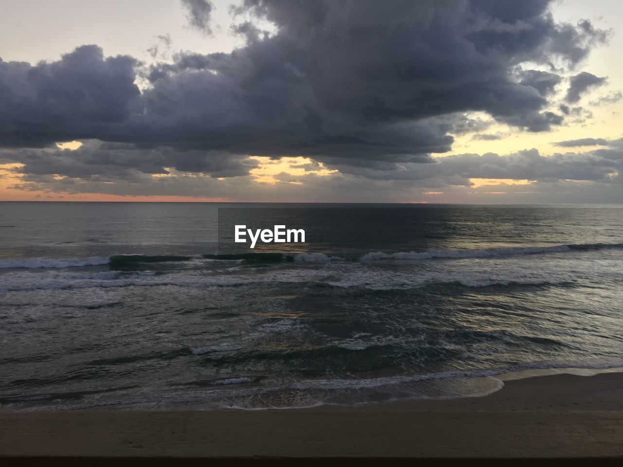 SCENIC VIEW OF BEACH AGAINST SKY DURING SUNSET